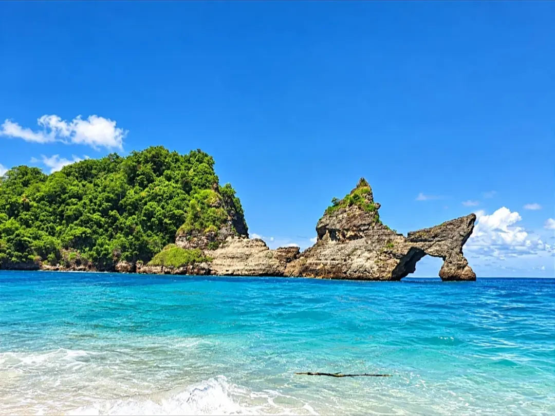 Turquoise beach and natural rock arch on the east coast of Nusa Penida