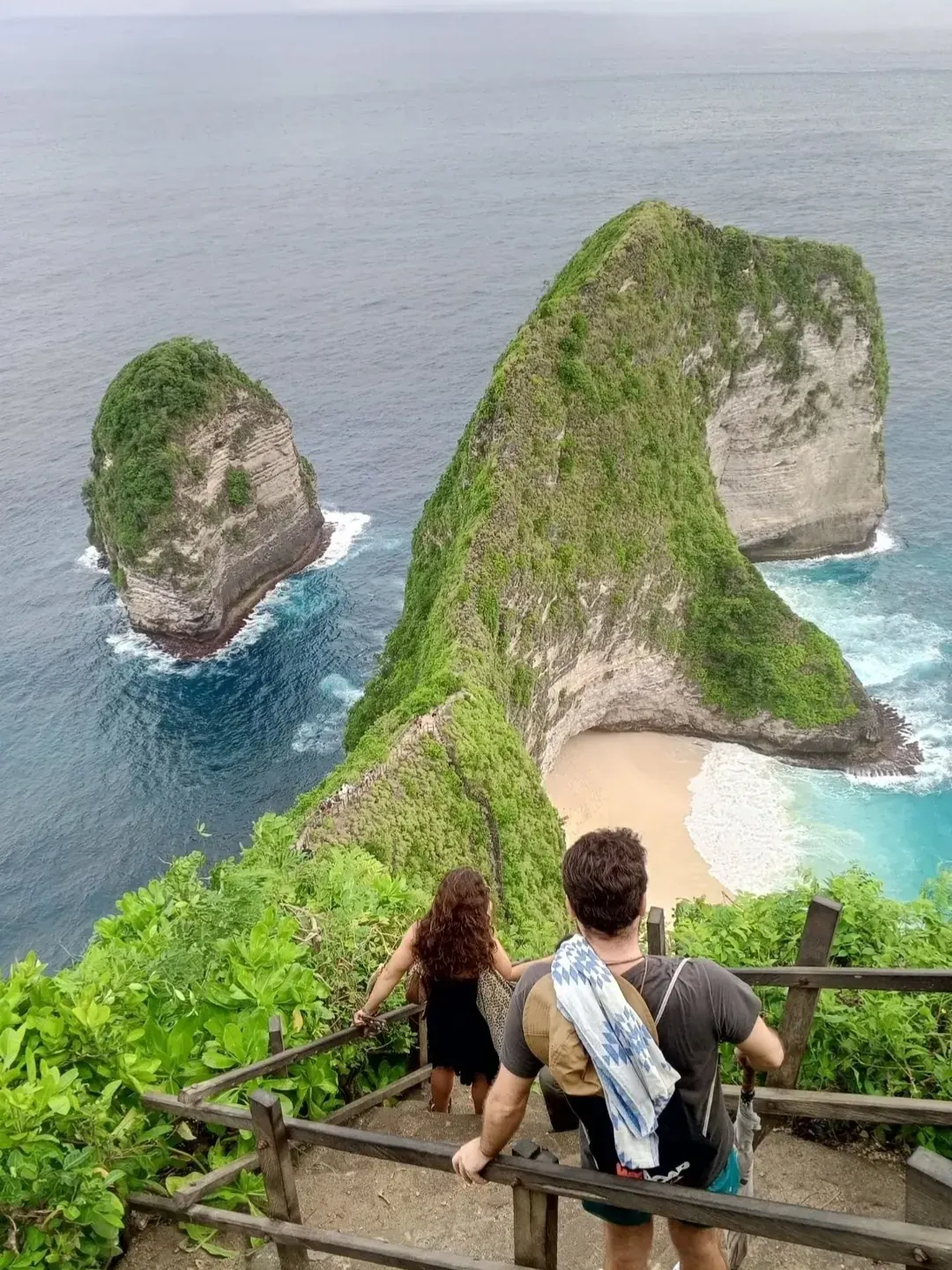 Visitors overlooking the green cliffs and beach of Kelingking, Nusa Penida